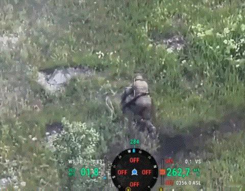 一名俄军士兵趴在地上，跌跌撞撞地爬进了灌木丛。他以为钻进这片低矮的植被，就能躲过