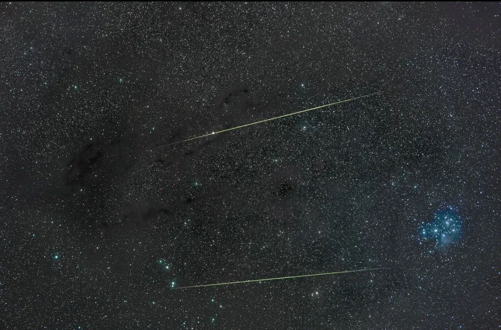 这张照片中的两颗明亮流星穿越了星空，光芒四射，将猎户座流星雨的活跃画面展现得淋漓