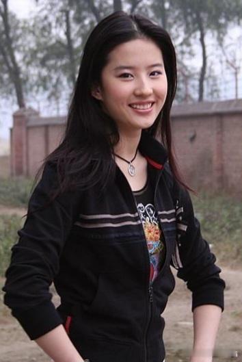 刘亦菲这次的上衣选择了黑色连帽拉链运动外套，衣身上的浅灰条纹与侧边装饰细节，为整