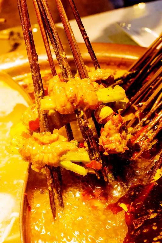 12月2日四川成都，女子成都旅游吃串串地摊火锅，目睹老板将别人吃剩的锅底，倒回共