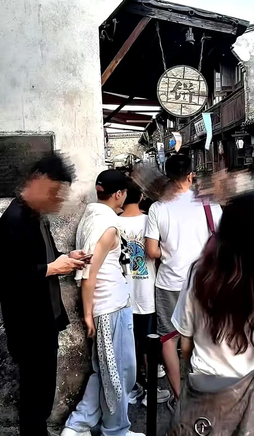 乌镇青石板路上，张艺兴排队买包子的侧影成了最生动的反差——褪去舞台华服，素颜白到