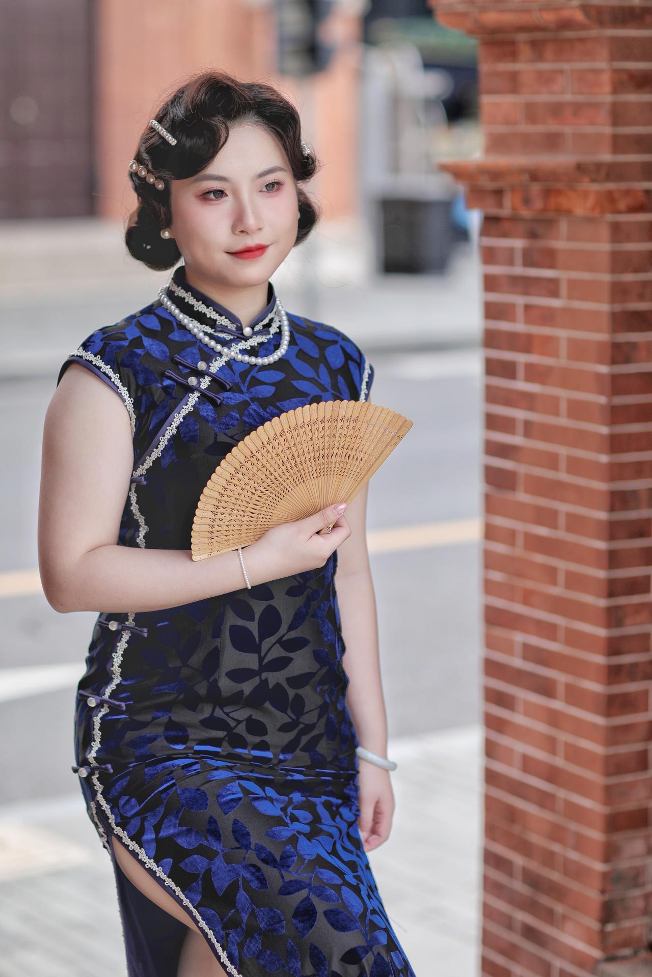 沪沪上旧梦
一袭藏蓝暗纹旗袍勾勒出民国女子的绰约风姿。珍珠领饰衬得脖颈纤细，白边