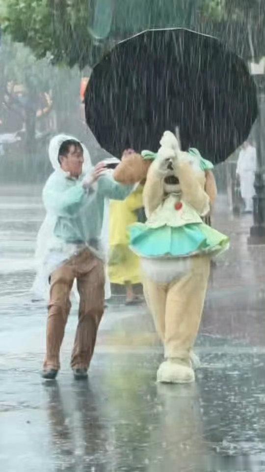 台风天上海迪士尼互动人偶照常出街喔唷，敬业是一回事，但安全是更重要的事啊。台风天