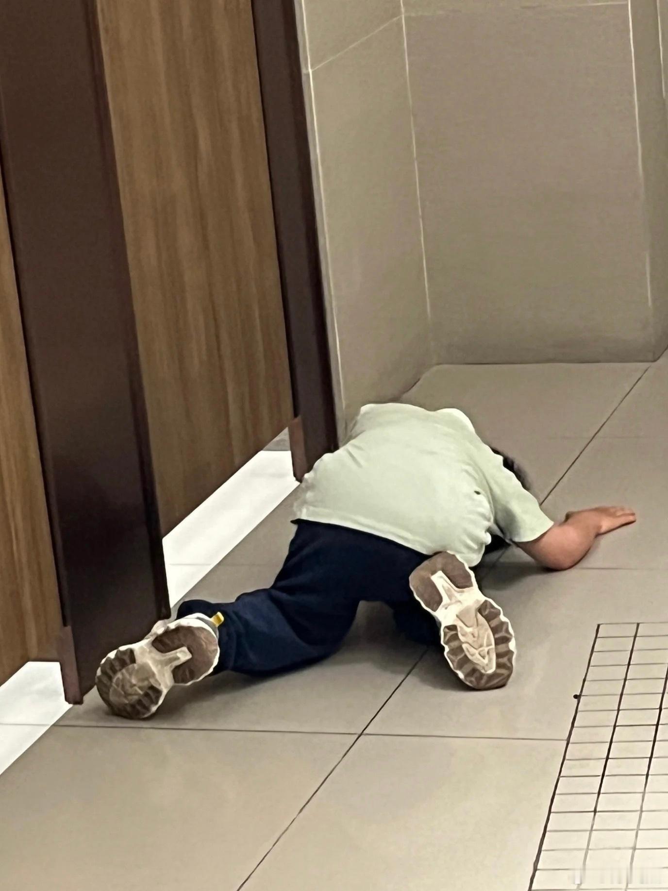上完厕所出来看到个小男孩，在一个个推开厕所门，然后又趴在地上…… 