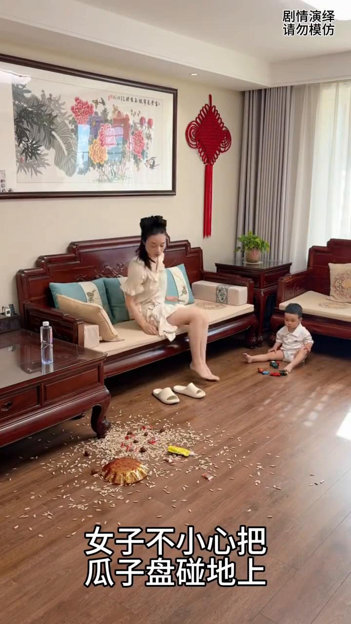 妈妈将瓜子盘碰洒在地上，下一秒她成功嫁祸给儿子。
女子不小心把瓜子盘碰地上，这时