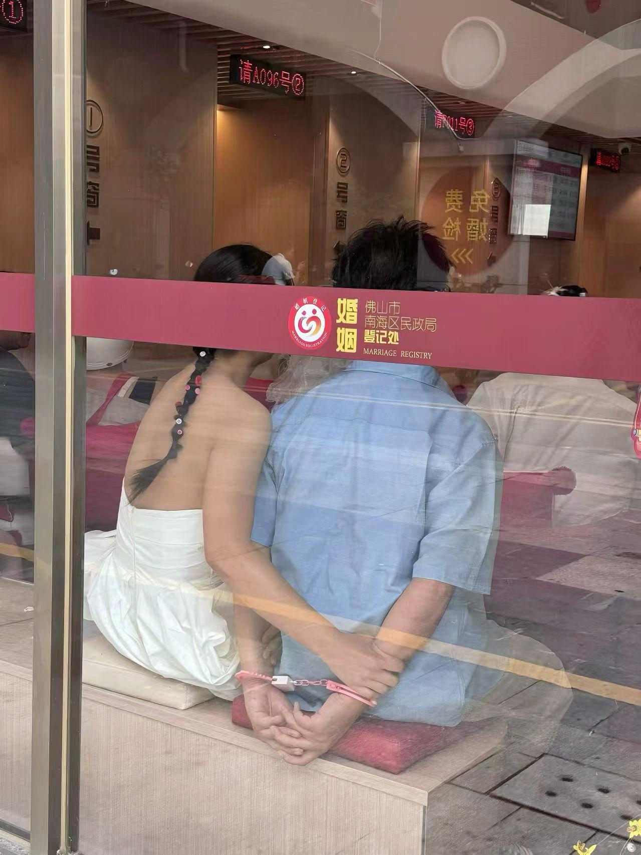 一对在民政局领证的新人，男人的粉色手铐很是形象！民政局领证合影