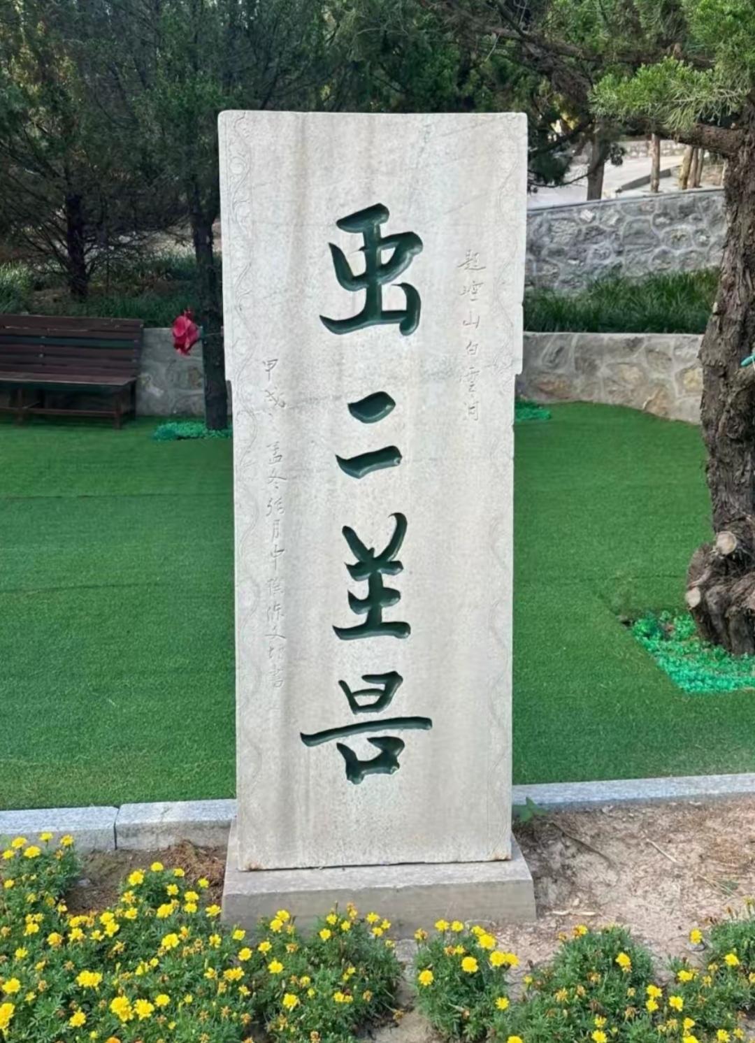 石碑上写着什么字？周围有花和树。这几个字有人能读出来吗？听一下。[作揖]路旁边的