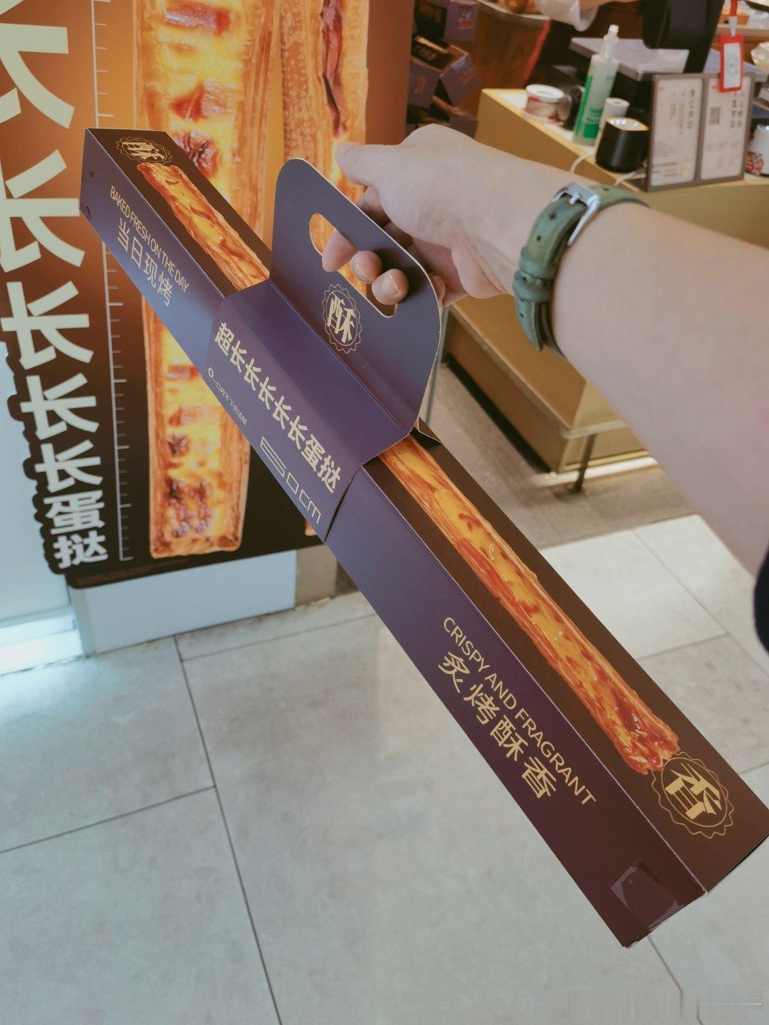 饭后散步随手拍 经过点心店，看见最近很火的超长蛋挞，给瘦巴巴少爷买了一只，他不怕