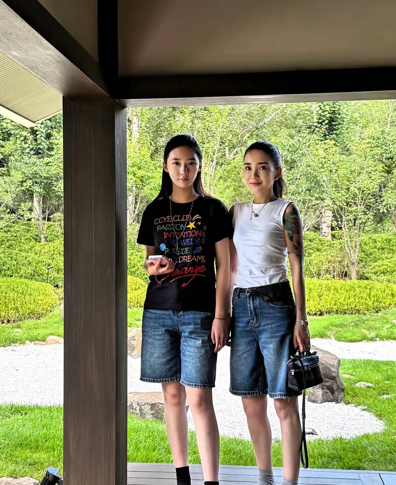 入目真好看，
亭廊并肩站。
本是母女俩，
含笑向远看。