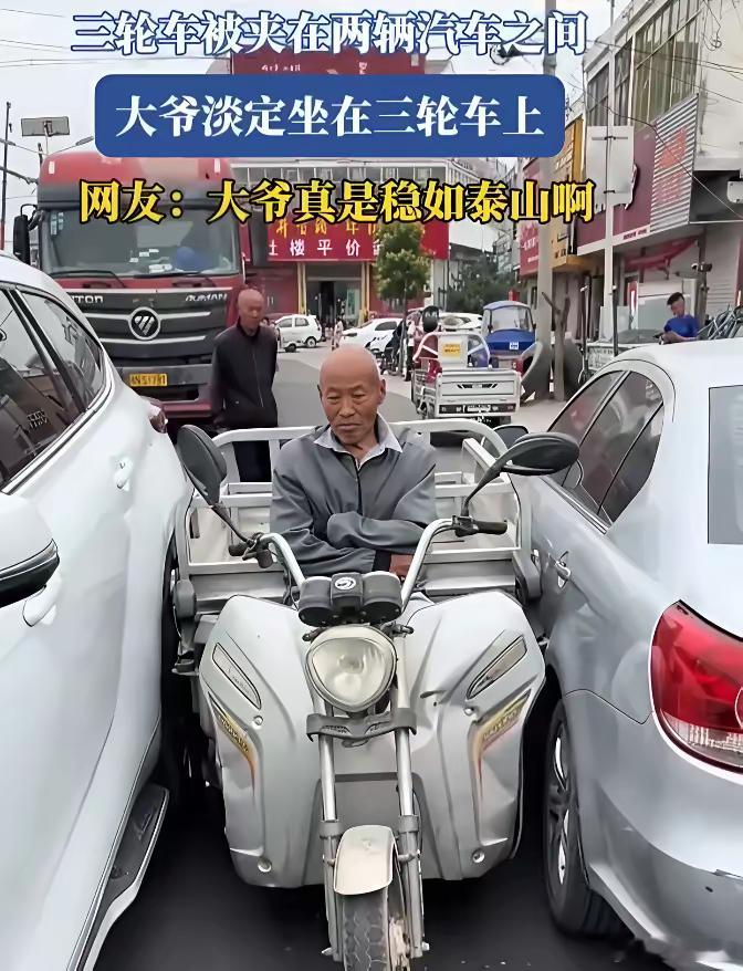 三轮车被夹在中间，大爷双手插腰，淡定的坐着，责任确实在大爷，但是他没钱赔，三方僵