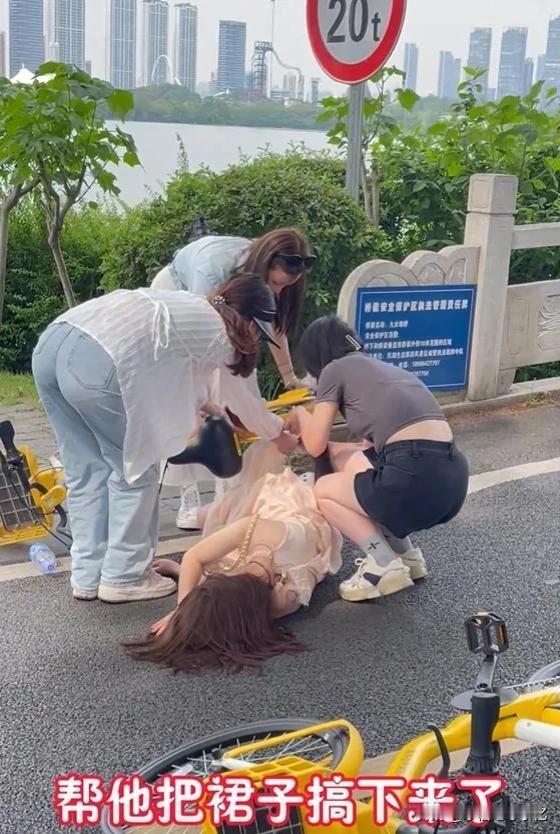 女子穿裙子骑自行车摔倒，裙子绞进车轮扯不出来遭围观