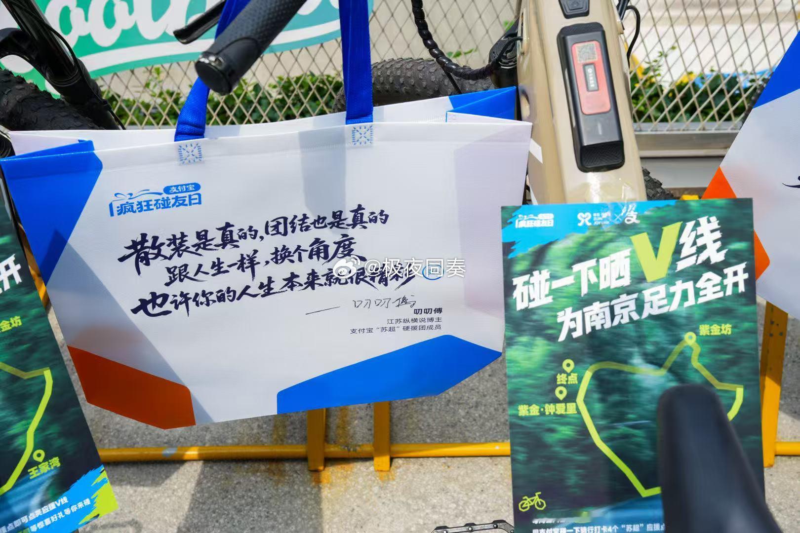 百店发支付宝助威袋为南京队加油被熙南里巨型足球装置吸引，排队体验射门互动。到手苏