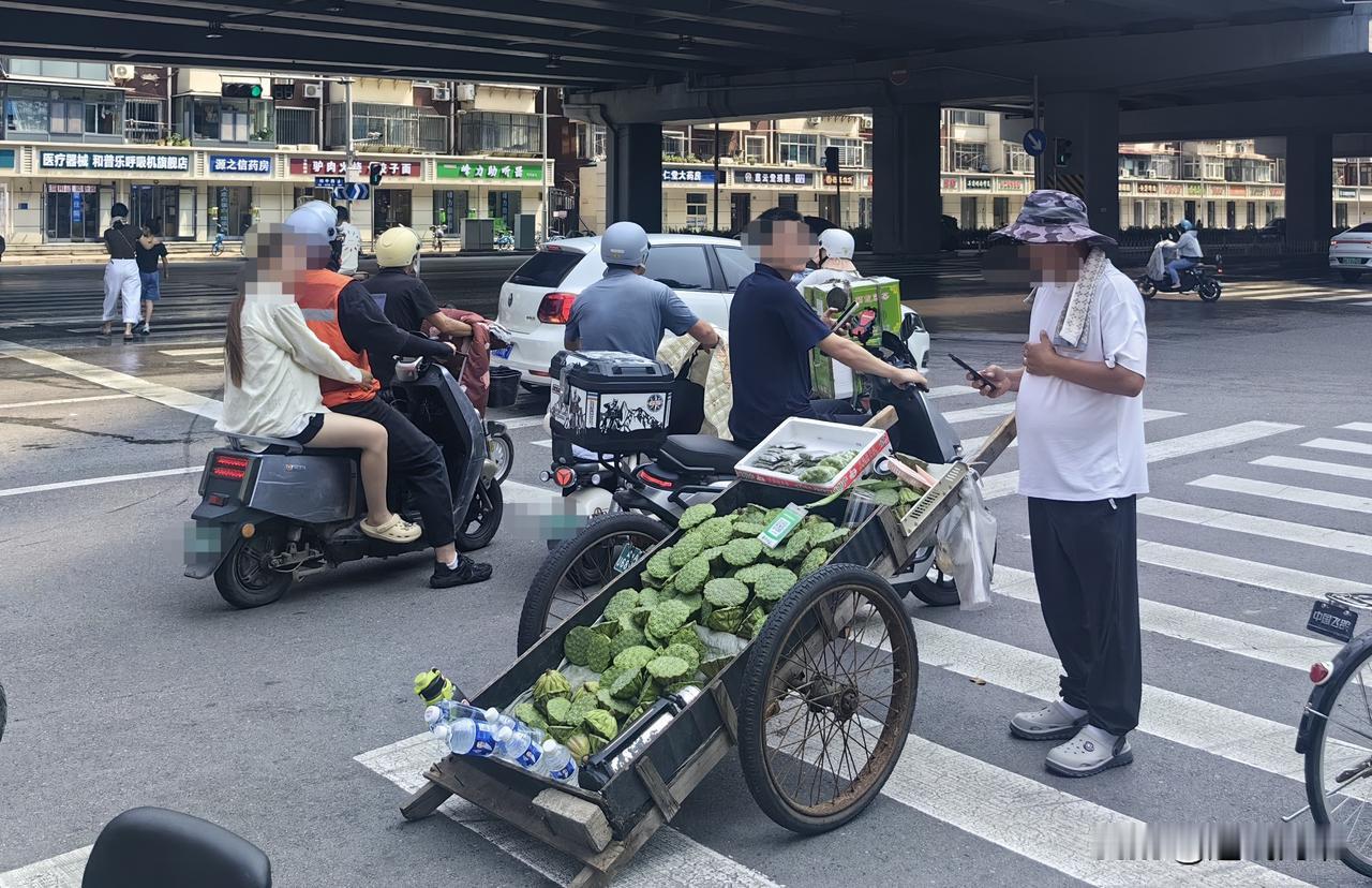 新鲜莲蓬路边开售】8月5日上午，在和平西路与水源街交叉口的斑马线处，一位商贩推着