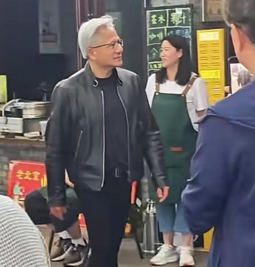 北京当天最高气温三十度，黄仁勋依然皮夹克出行，他似乎在努力塑造亲民的形象，大口炫