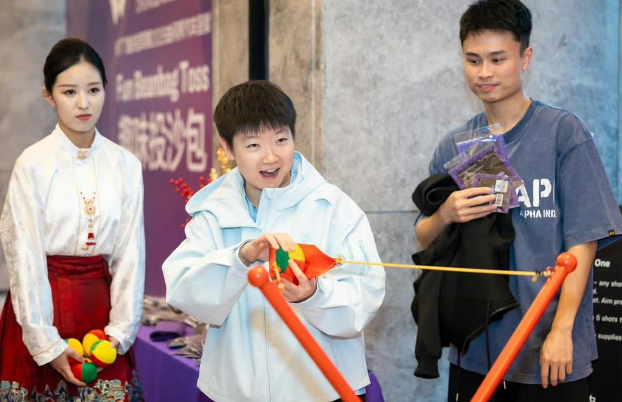 WTT重庆冠军赛欢迎晚宴上，参与主办方准备小游戏和体验项目的国乒女队队员孙颖莎、