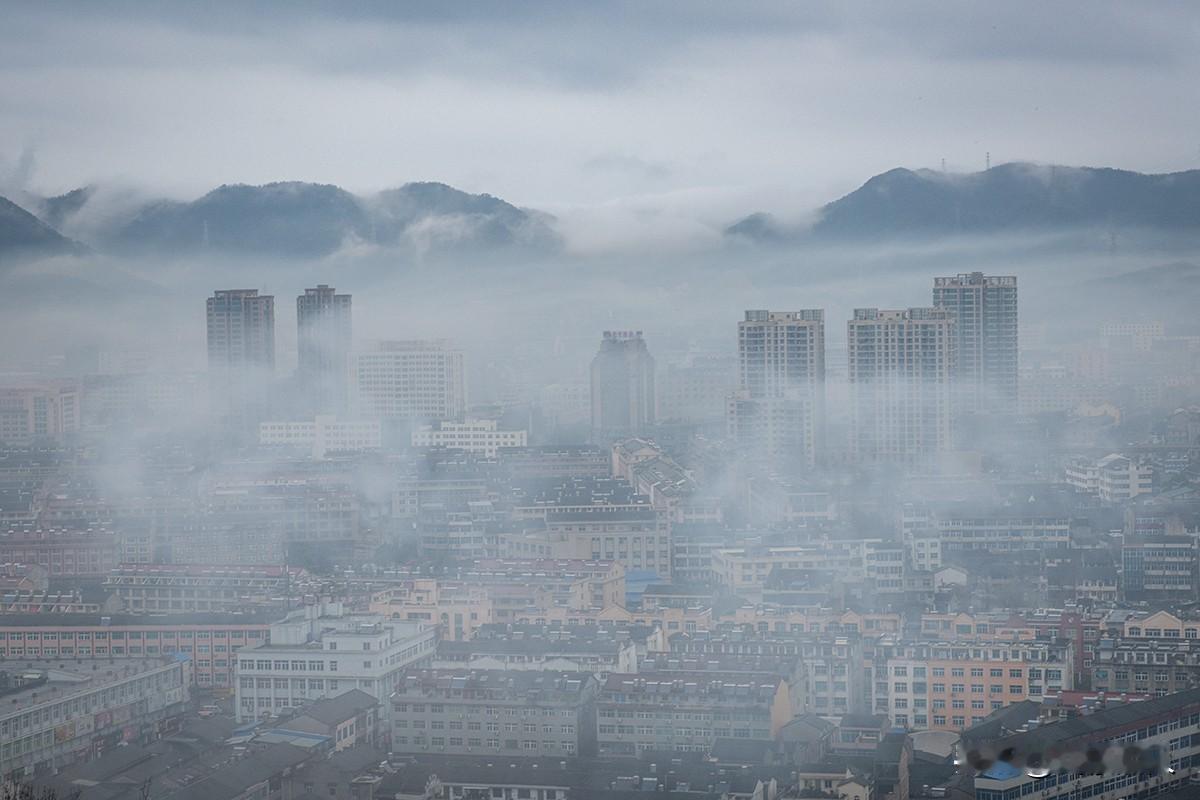 雾锁大溪
       晨雾漫过温岭大溪镇，远山隐现如黛，高楼半露似海市蜃楼。小