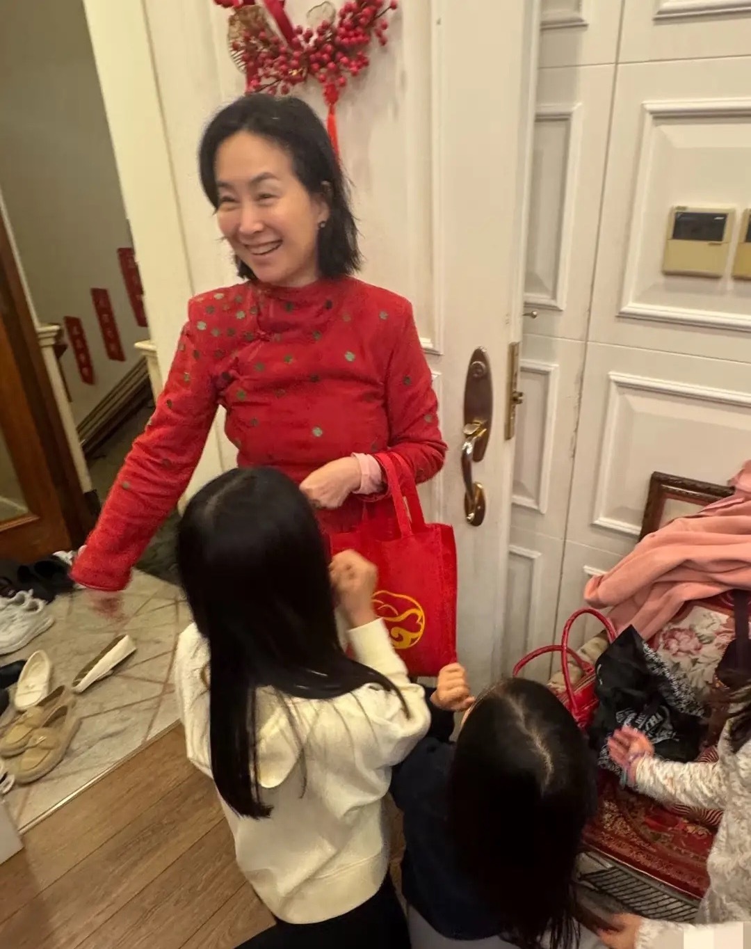 何超琼新年和干女儿一家一起过年，穿红色衣服很喜庆，状态很年轻！ 
