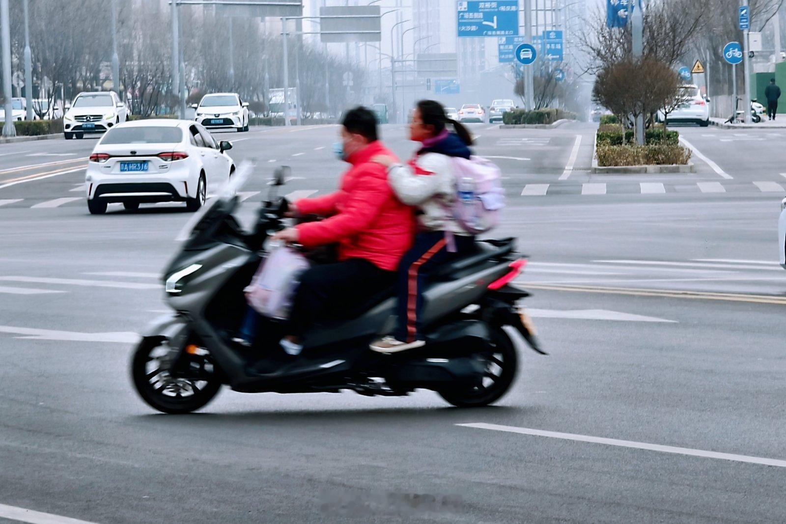 某学校门口看见的接娃场景，不戴头盔+红灯路口逆行左转。要是电驴我也就不说啥了，这
