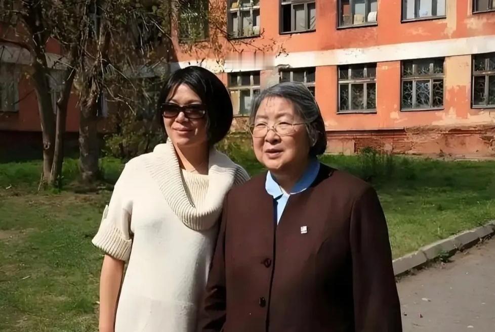 孔东梅陪母亲李敏站在老楼前，当初的那个孩童，已是白发苍苍的老人。

这个画面是，
