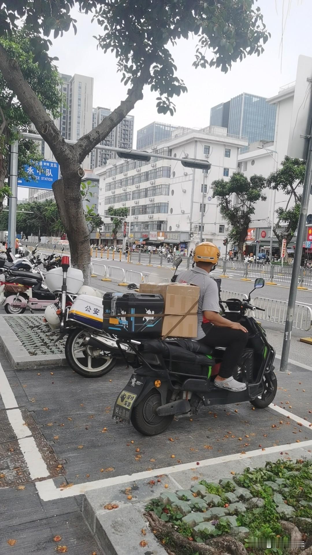在深圳的街头巷尾，电动车绝对是“隐形王者”！看这张图：骑手戴着黄头盔，电动车后座
