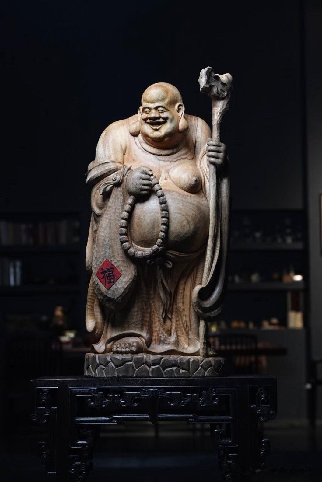 看见这样的弥勒，总会让人忍不住跟着笑起来。

香樟木温润质朴，天然木纹与刀痕相映