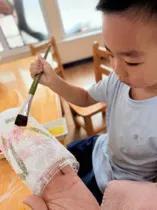 晒图笔记大赛幼儿园的小朋友们正在开心地粘彩盒。五颜六色的纸盒摆在桌上，孩子们拿着