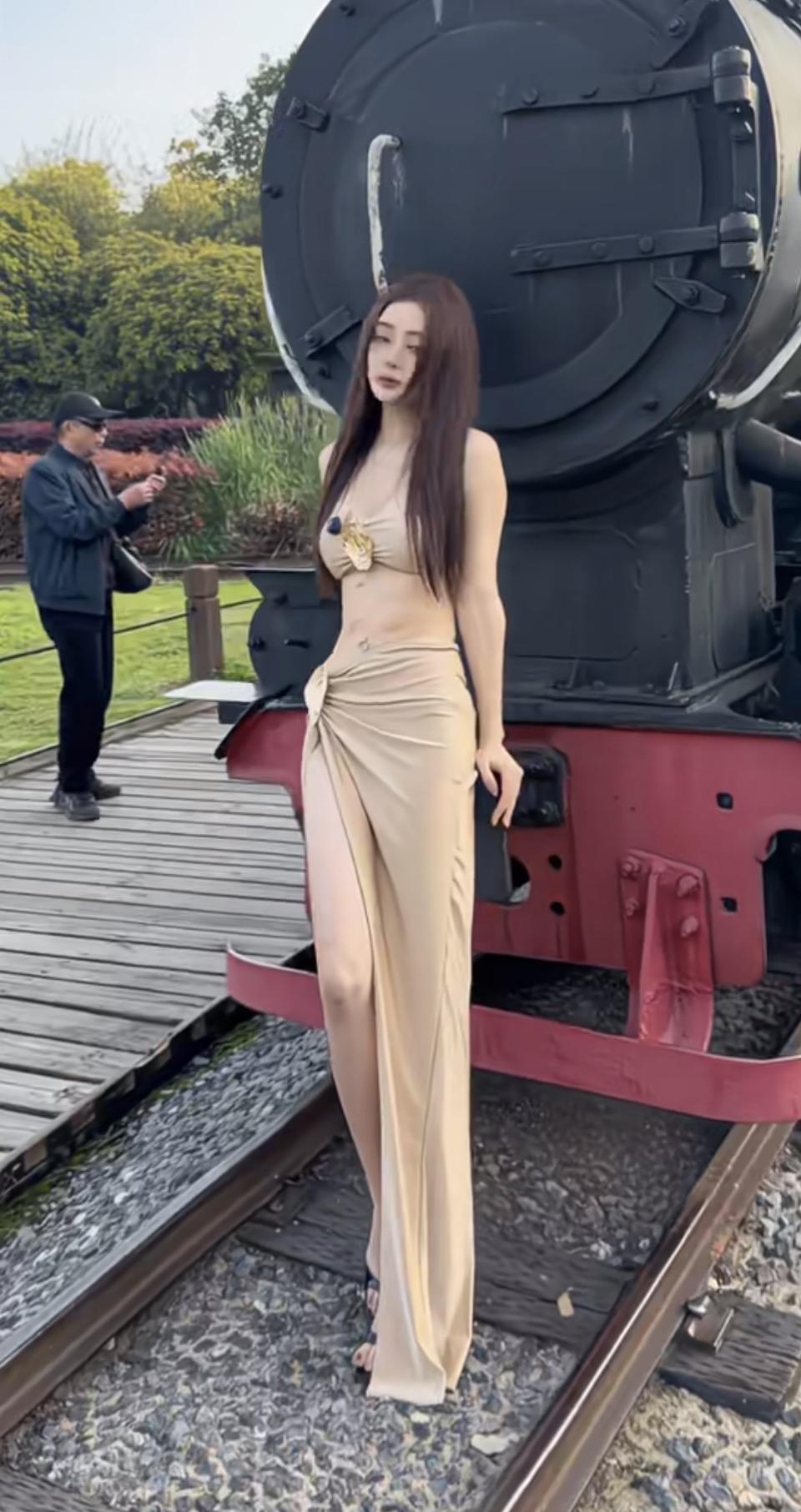 复古火车前的优雅女神，长裙飘飘，气质非凡。