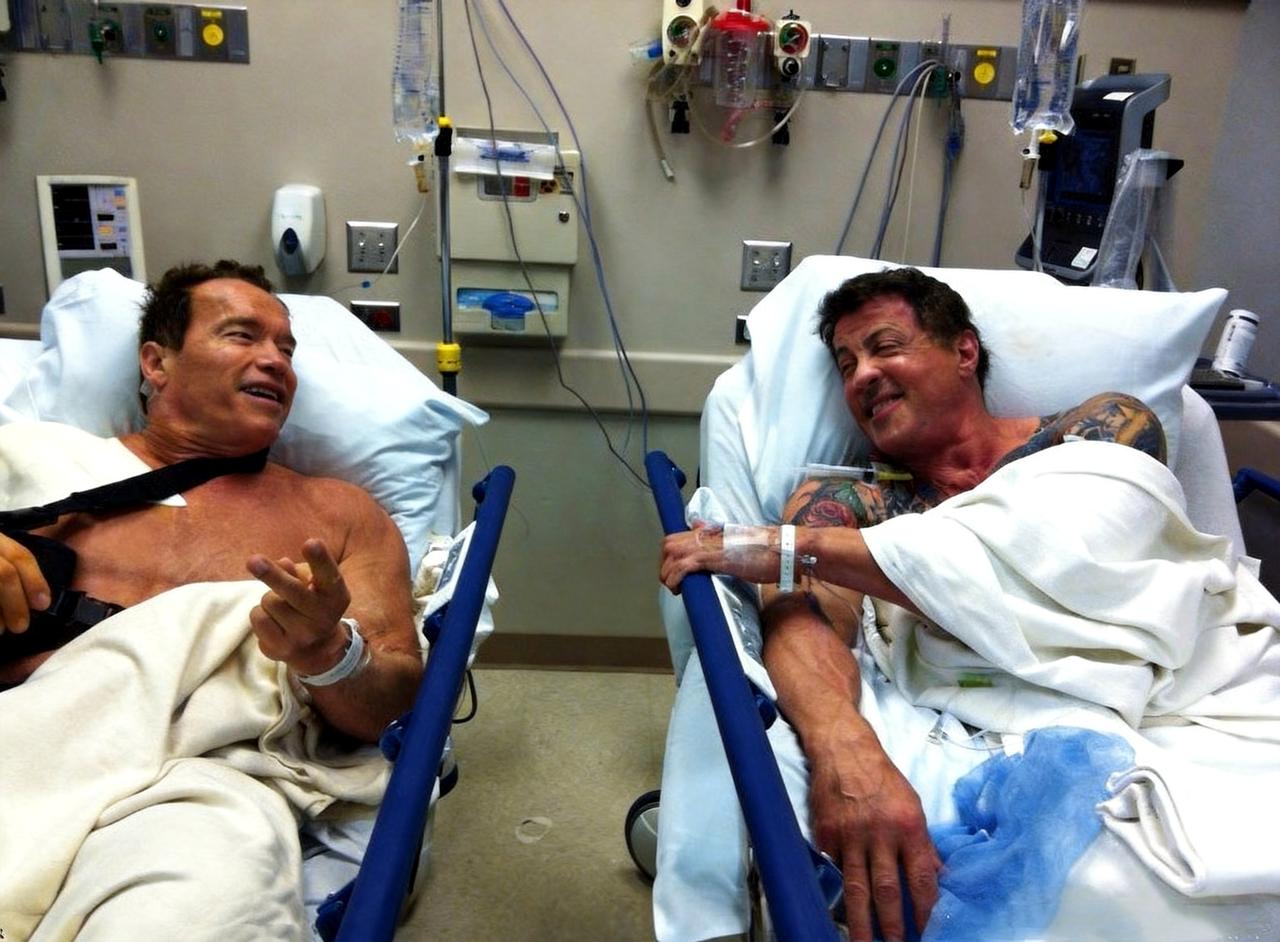 这是2012年两名荧幕壮汉施瓦辛格与史泰龙在医院同一病房相逢。人高马大、虎背熊腰