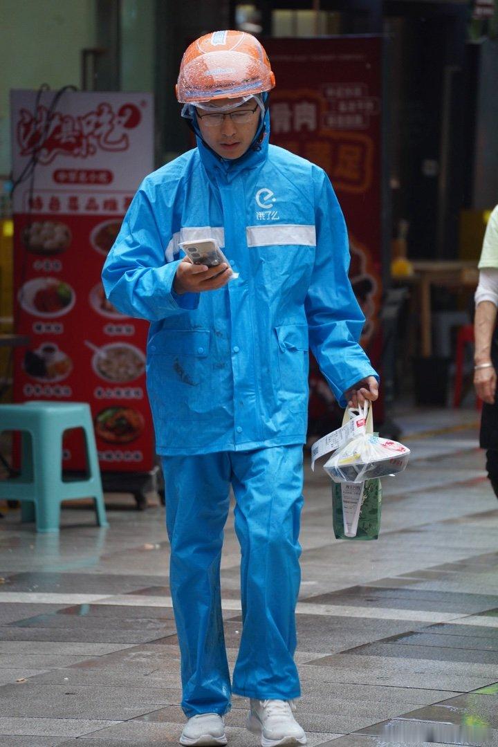 街头风雨后各色雨衣小哥遍地走 