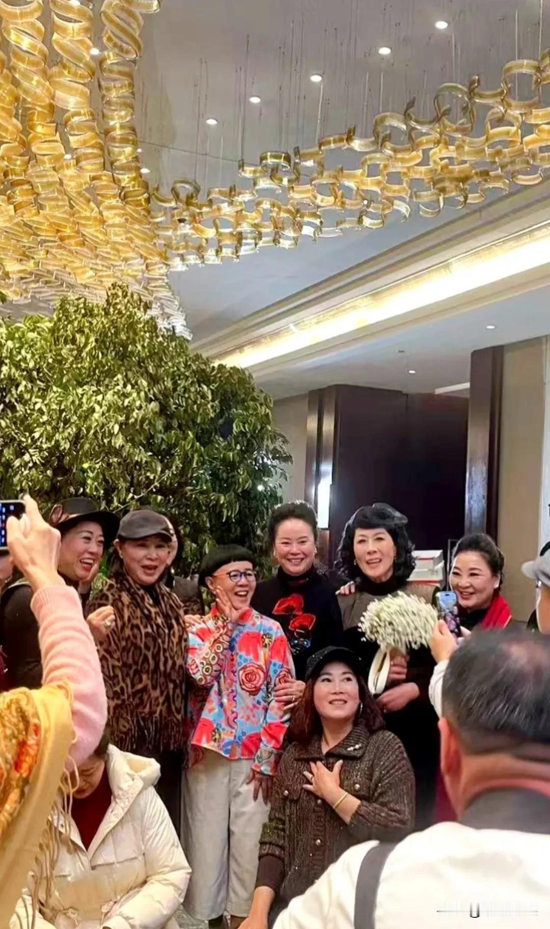 前央视主持人金龟子参加活动，她穿着一件红花外套，灰白色裤子，脚踩增高鞋，戴着眼镜