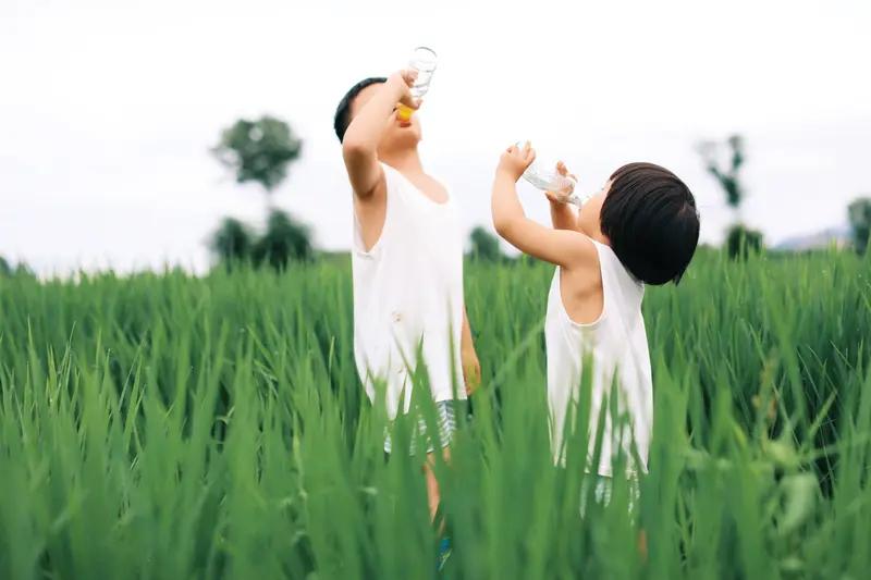 云南一宝妈背着龙凤胎回家，路上撞见结婚车队，立马带着两个娃凑过去讨喜——这场景看