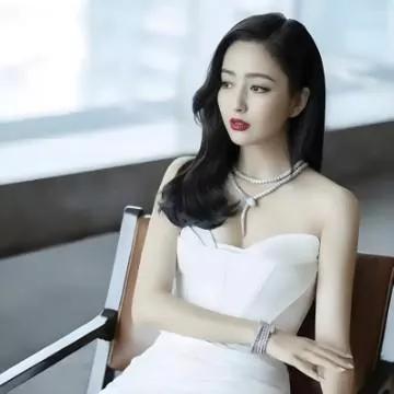 优雅黑发美人，穿着白色礼服，珠宝点缀，气质出众。