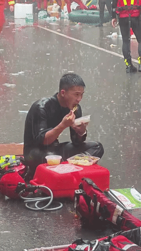 他席地而坐，在雨中吃饭！哪里有险情，哪里就有他们的身影，向所有挺身而出的救援英雄