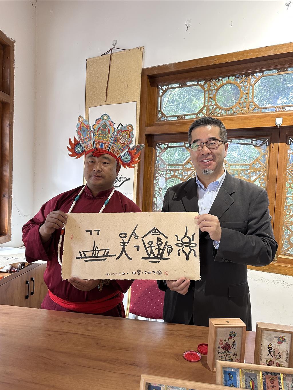 马英九基金会执行长萧旭岑与东巴文专家手书的 “两岸一家亲”。据马英九基金会28日