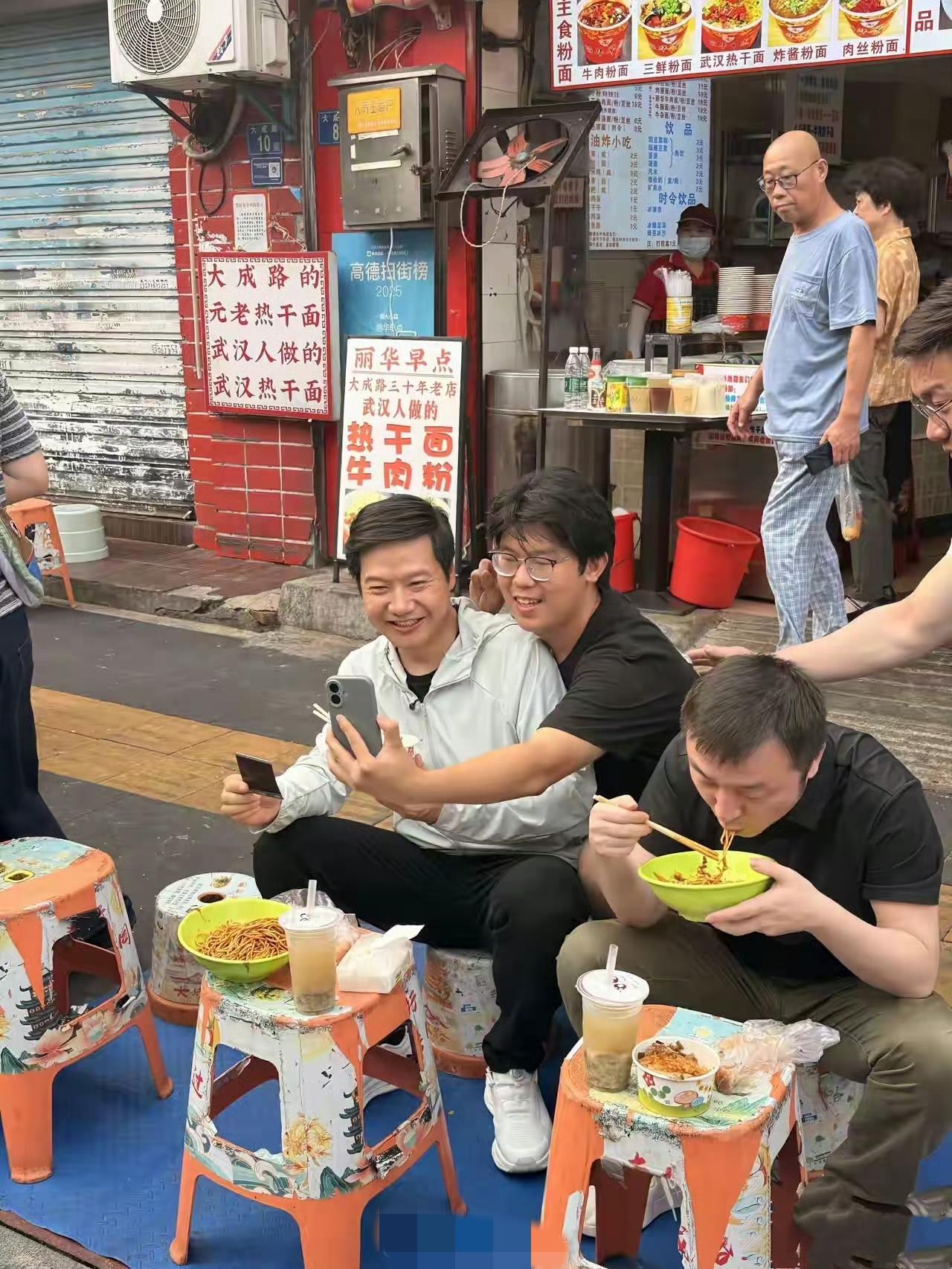武汉街头，雷军“过早”。路过的粉丝纷纷掏出手机拍照打卡，快60岁的雷布斯真心不显