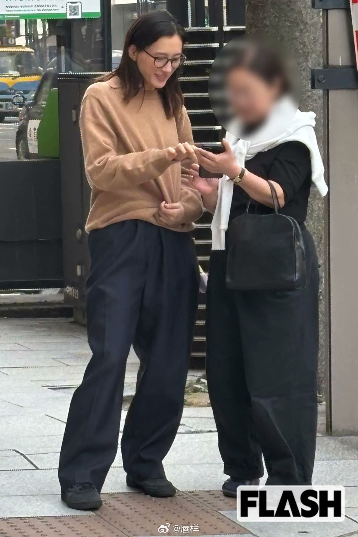 三月下旬的银座大街，正值傍晚，街上满是访日游客，热闹非凡。一位戴眼镜的美女单手拿