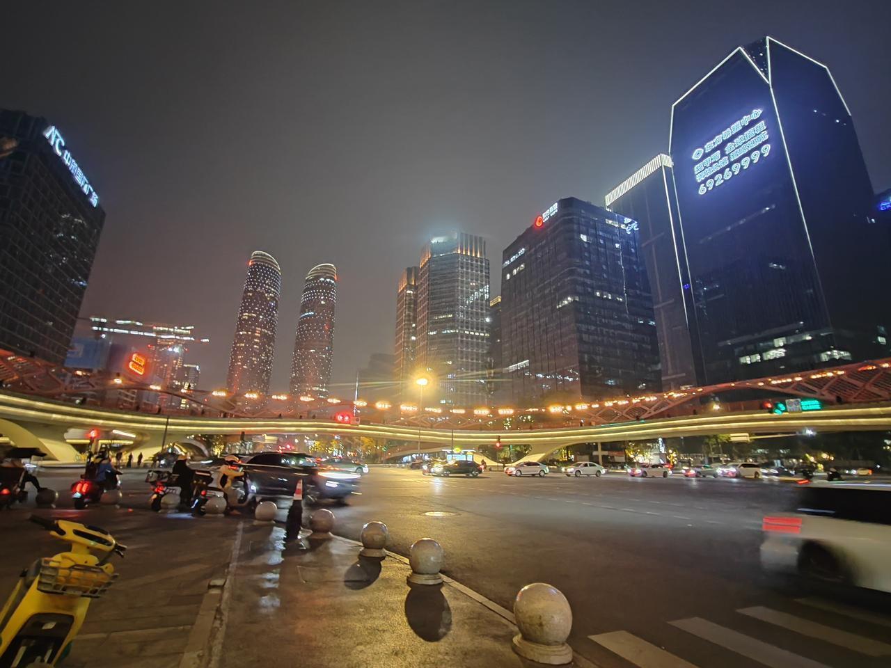 傍晚的天府双子塔像是浸在蜜糖里。天色从钢蓝褪成绒紫，两栋巨塔渐次亮起流光，玻璃幕