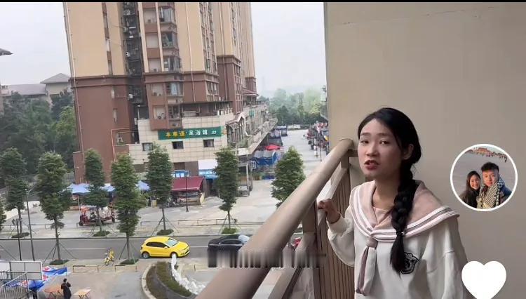 小松回家途中在昆明下榻的高楼阳台上，秋秋看着外面的高楼大厦，对小松说外面的高楼多