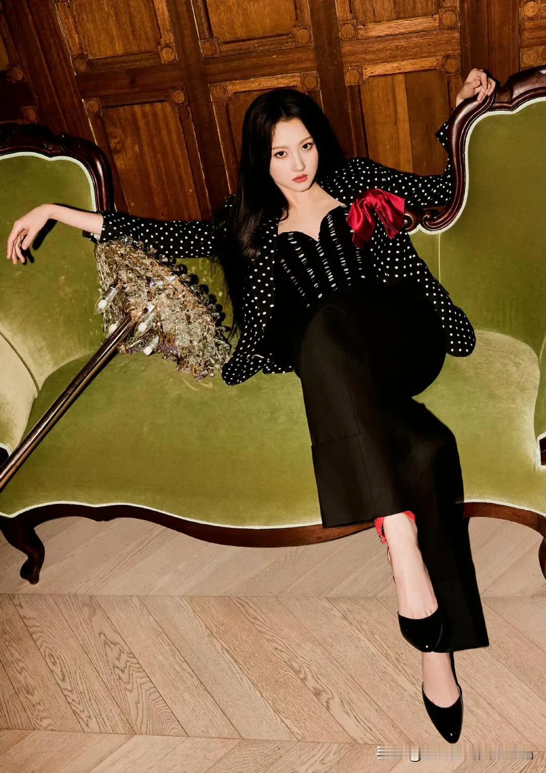 关晓彤身着波点西装外套，搭配黑色长裤，红丝带与红鞋跟巧妙呼应，在复古氛围的空间中