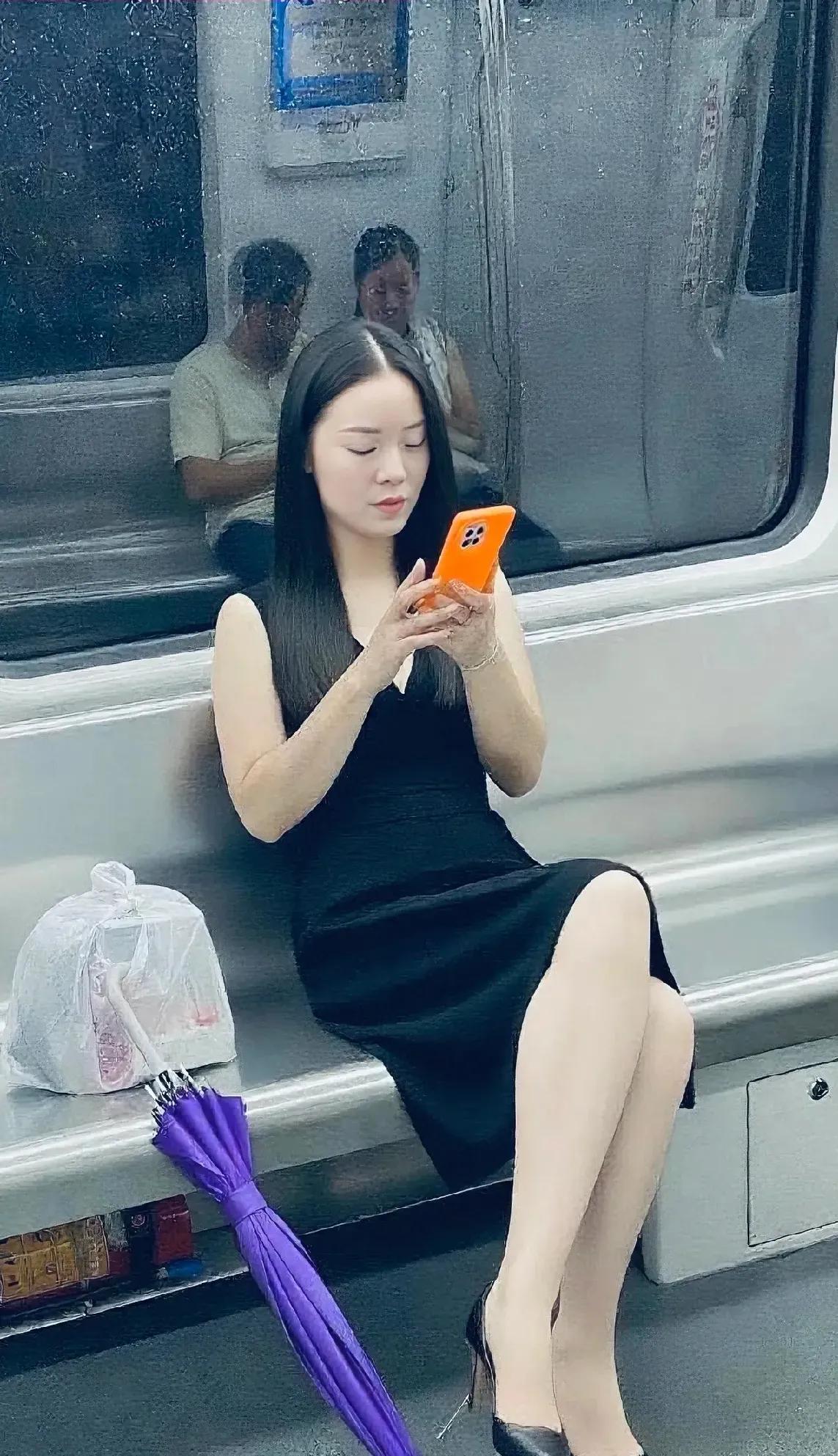 地铁上的优雅时光，黑裙与橙光相映成趣。