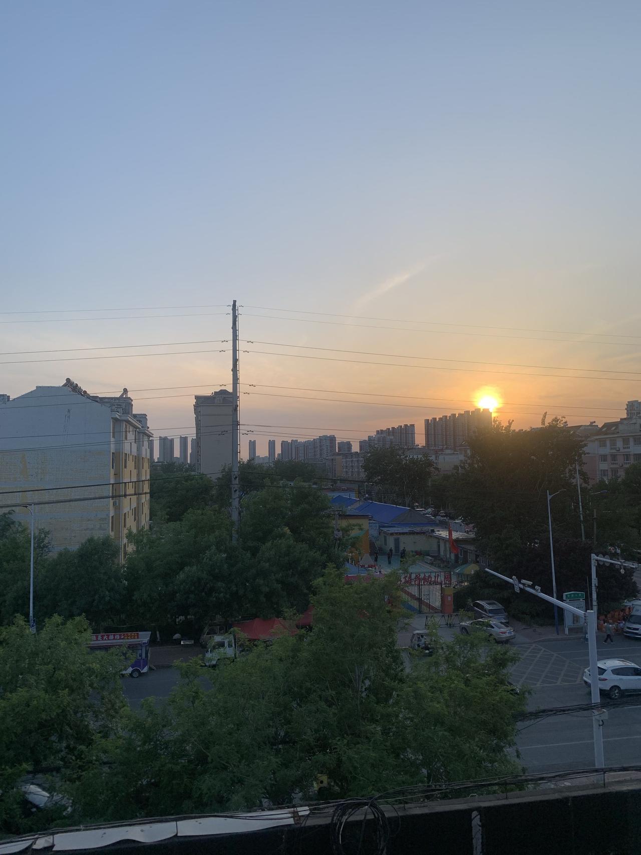 继续做任务，打卡记录我可爱的家乡。夕阳西下，余晖映照着这座城市，把所有的建筑物都