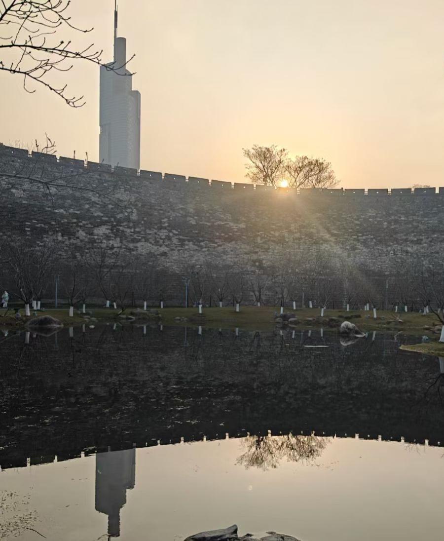 古城墙驮着落日的余温，把现代楼宇的影子，揉进了湖水的褶皱里，光阴在此刻，成了双面