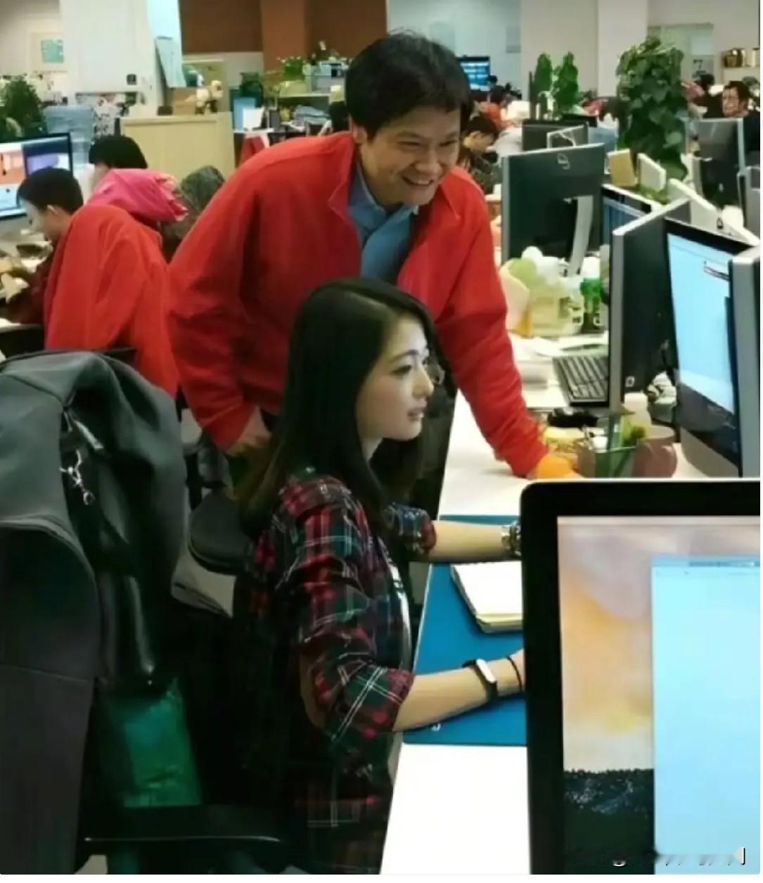 2014年，雷军在查看岗位时，与小米女工程师张功留下一张合影。张功侧面像一幅美女