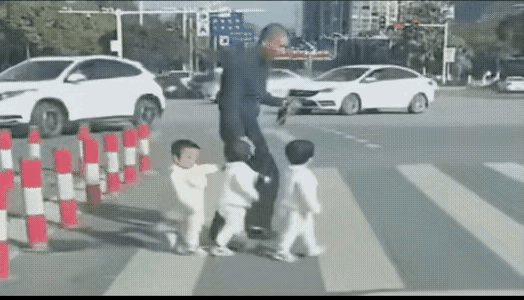 爷爷领着三个孙子过马路，这种过法实际上是很危险的，一个人领着三个孩子，有时候是控