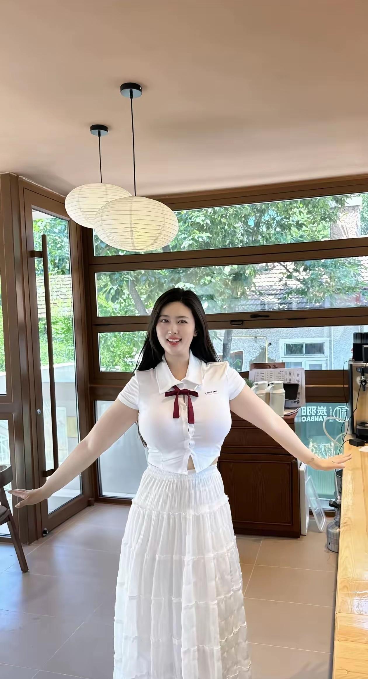 一个穿白色连衣裙的女孩在咖啡馆里微笑。