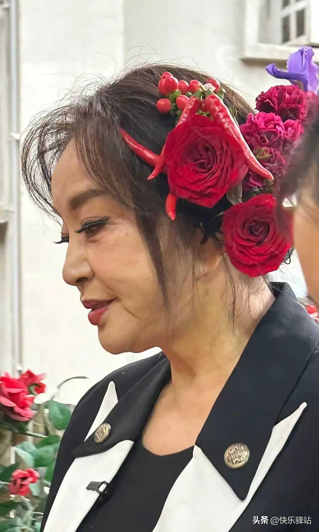 这两天刘晓庆在重庆吃火锅时被拍到，头顶大红花，假发片上还别着几颗细长的红辣椒。不