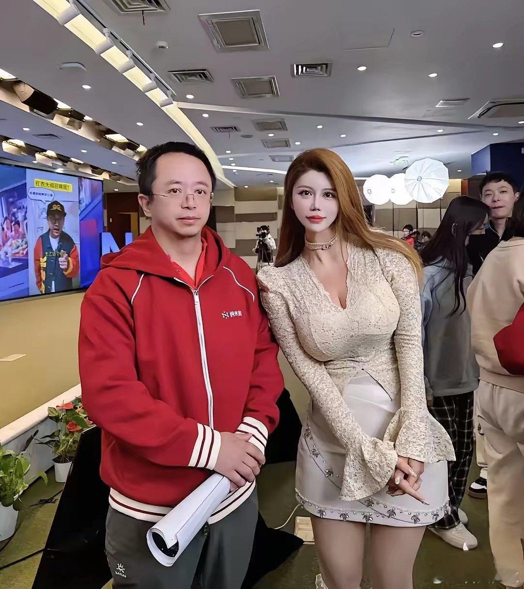 周鸿祎在北京和一位女网红合影，面对身边的美女，他显得有些拘谨，动作僵硬，实在是有