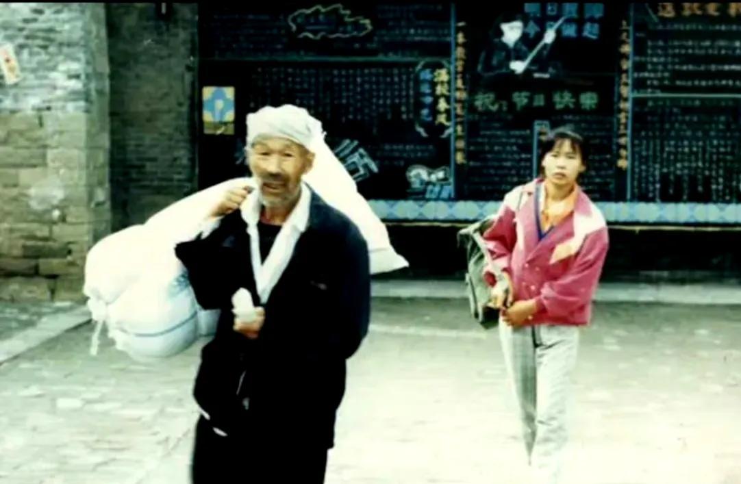 90年代初，陕北延安，一个老农民送女儿读中专时，留下了一幅感人的老照片，照片中的