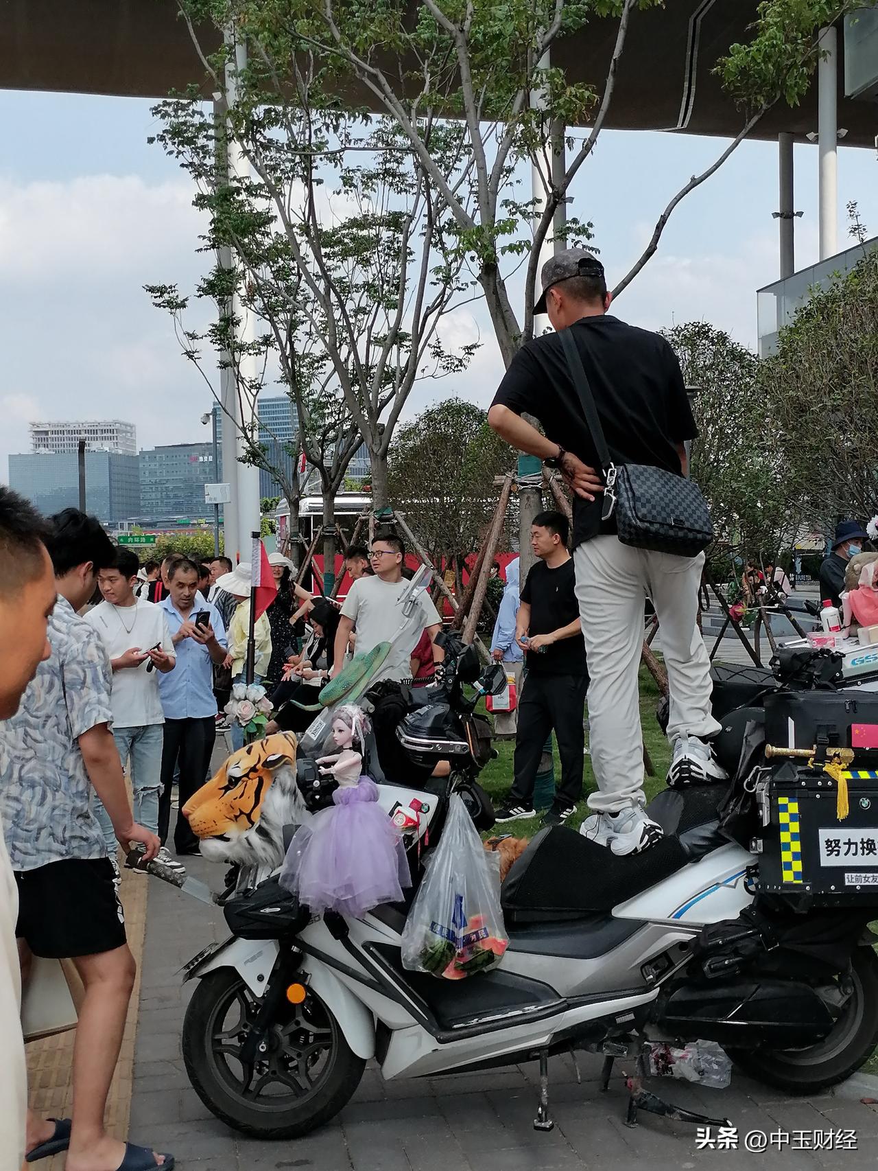 这样能找到心仪对象吗？一位小伙子开着一个豪华的摩托车，并停站在上面唱着歌曲，地面