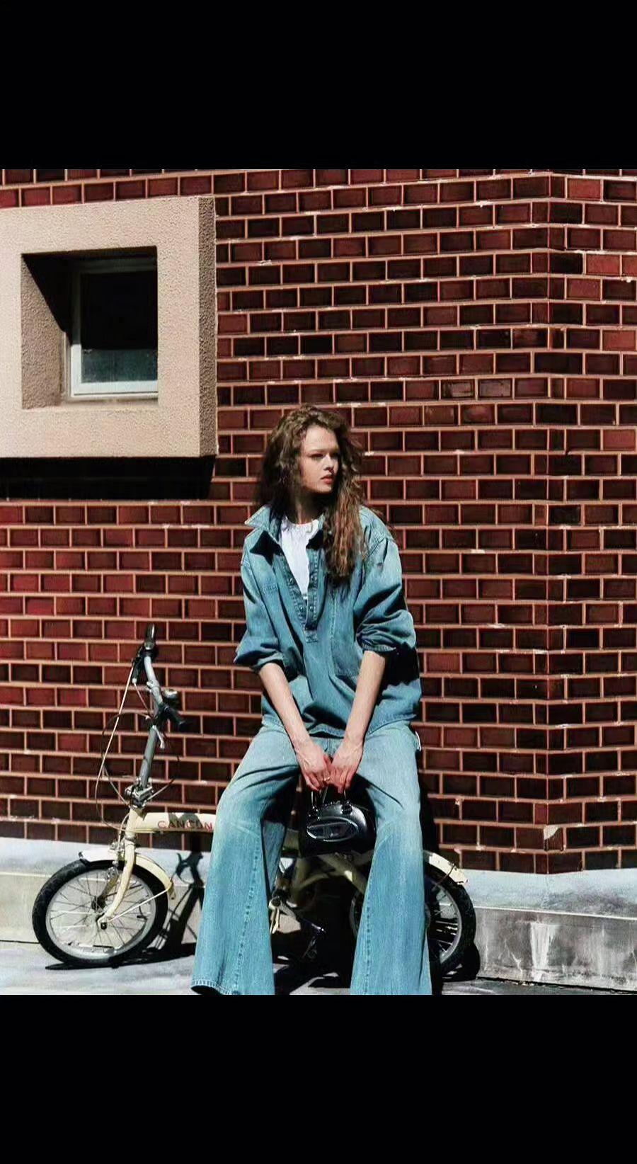 🚲砖墙上的斑驳日光，是时光洒下的碎金✨。牛仔与单车的邂逅，青春在转角处打盹☕。